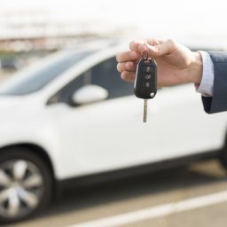 businessman-with-keys-front-car_23-2147986531