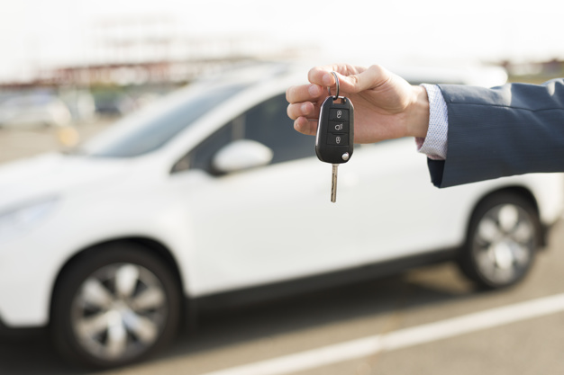 businessman-with-keys-front-car_23-2147986531