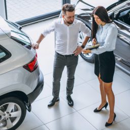 salesman-woman-looking-car-car-showroom_1303-13643