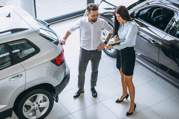 salesman-woman-looking-car-car-showroom_1303-13643
