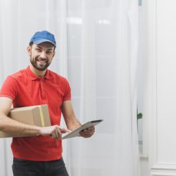 cheerful-delivery-man-with-tablet-box_23-2147801215