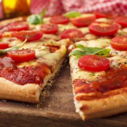 tasty-pizza-with-cut-slice-chopping-board_23-2147926085