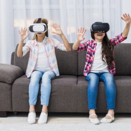 close-up-girls-sitting-sofa-touching-air-during-vr-experience_23-2148080311