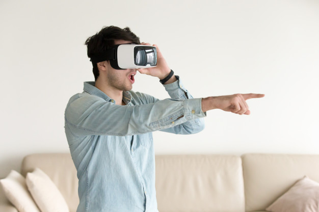 excited-young-guy-experiencing-virtual-reality-wearing-vr-headse_1163-5265