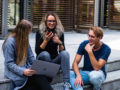 three-persons-sitting-on-the-stairs-talking-with-each-other-1438072
