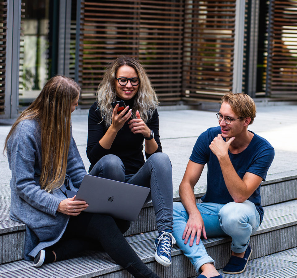 three-persons-sitting-on-the-stairs-talking-with-each-other-1438072